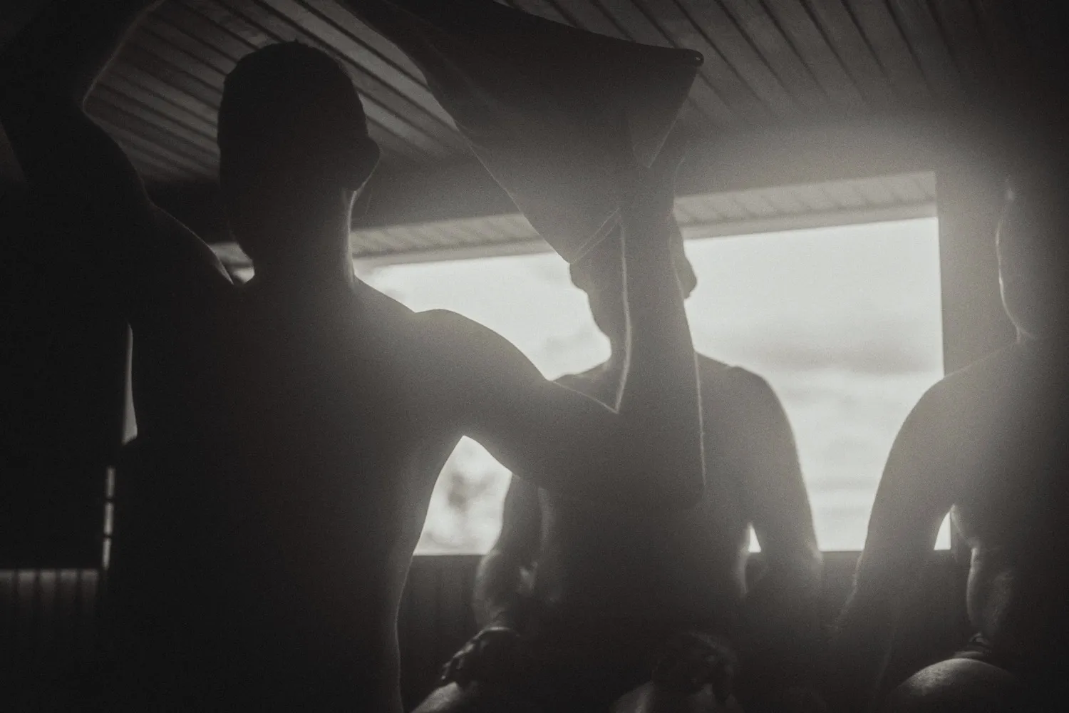 An Aufguss ceremony in a sauna, towels raised in silhouette